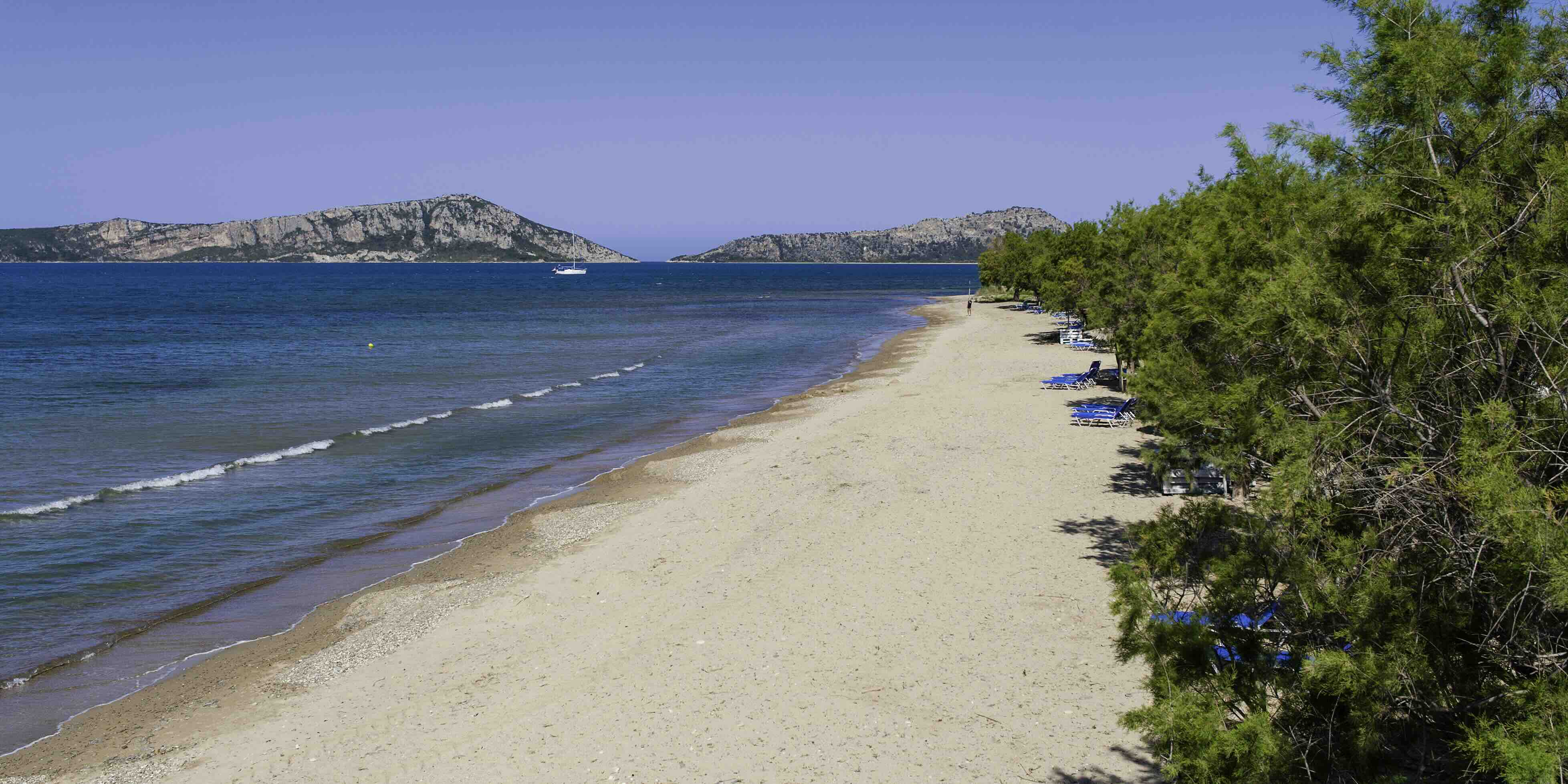 Sandy beach of Gialova with clear turquoise waters and tamarisk trees, steps from Erodios Camping
